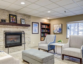 A living room with a fireplace, a couch, a chair, and a bookshelf. AI generated content